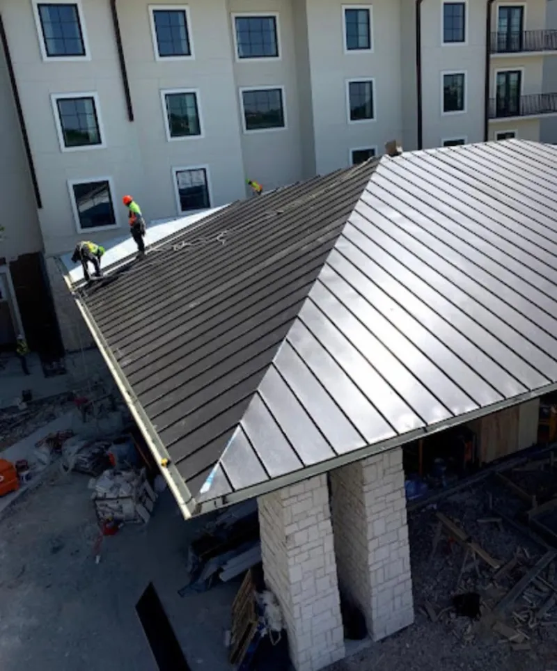 Crew installing standing seam metal roof panels on a commercial project in Massapequa Park